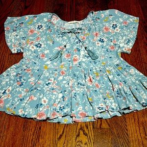 Multicolored flowery pattern with teal base. Blouse is flowy and comfortable.